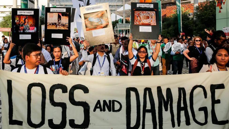 المتظاهرون يرفعون لافتات ولافتات في COP28