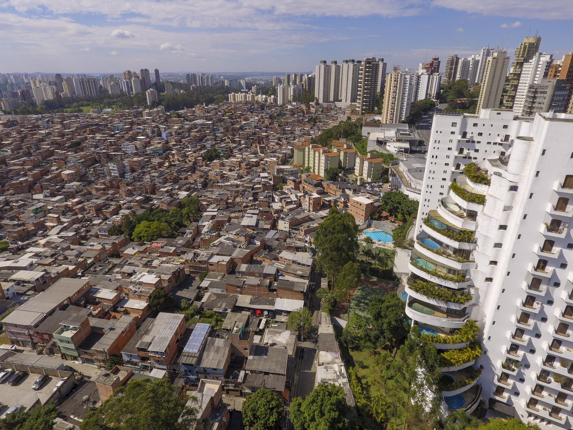 Prédio rico com piscinas na varanda ao lado da favela de Paraisópolis, em São Paulo