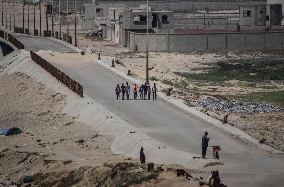 نازحون فلسطينيون من مدينة غزة يسيرون على طول ممر الجيش الإسرائيلي في منطقة نتساريم