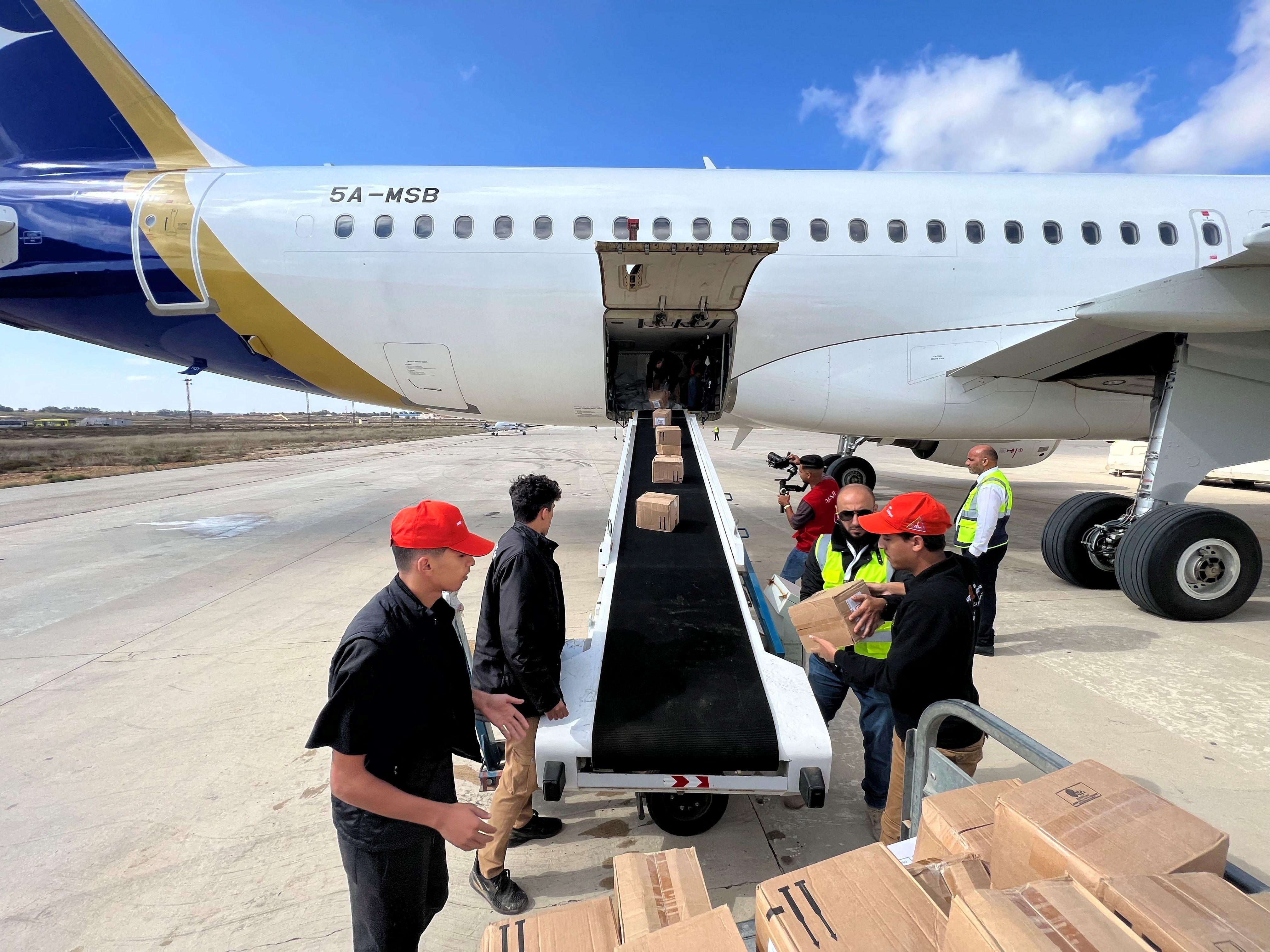 Voluntarios descargan un avión de ayuda humanitaria.