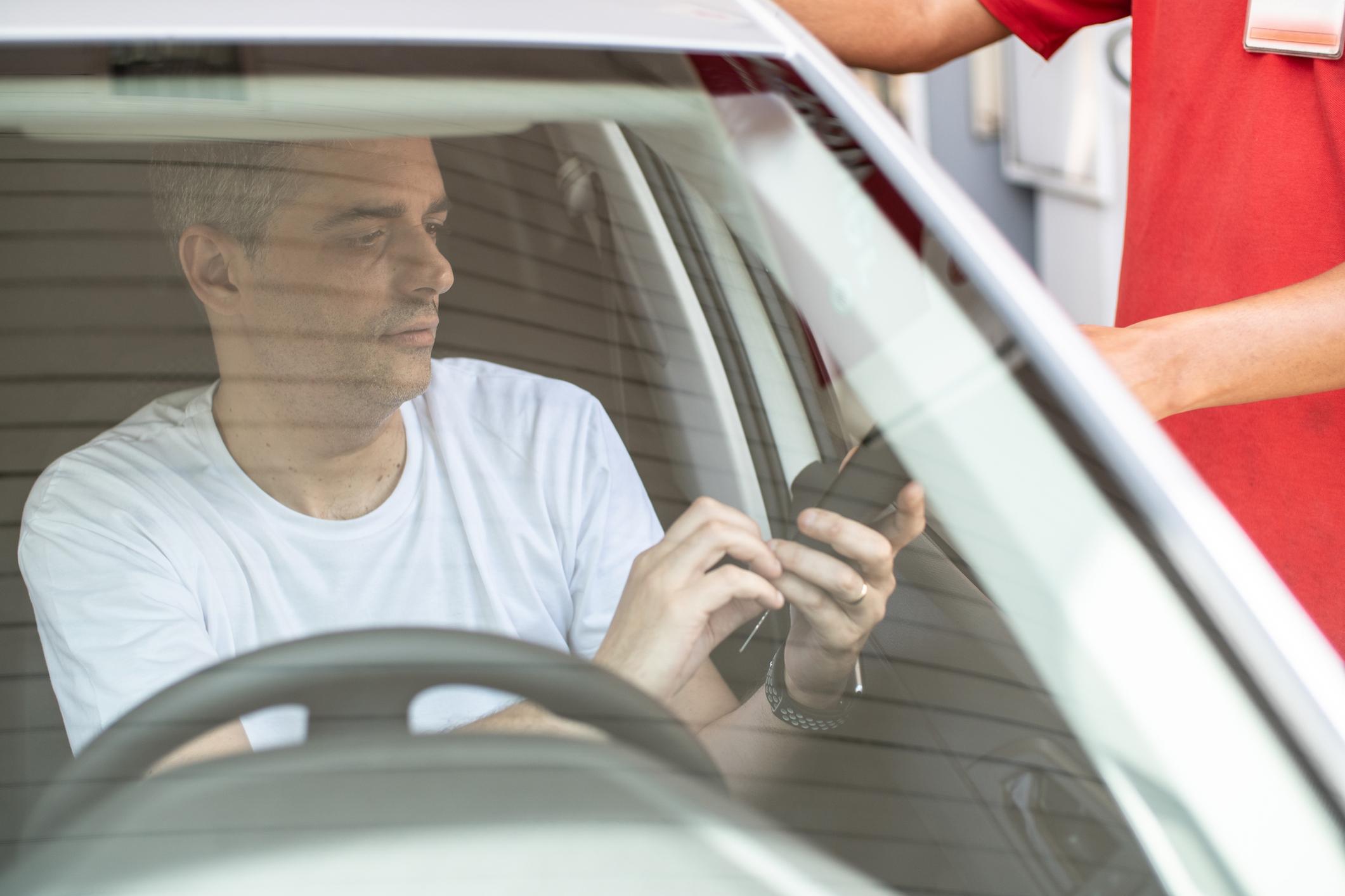 Homem pagando por combustível em posto de gasolina