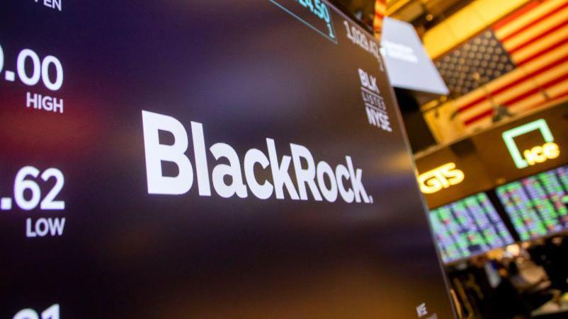 Un panel luminoso con cifras y el nombre de BlackRock. 