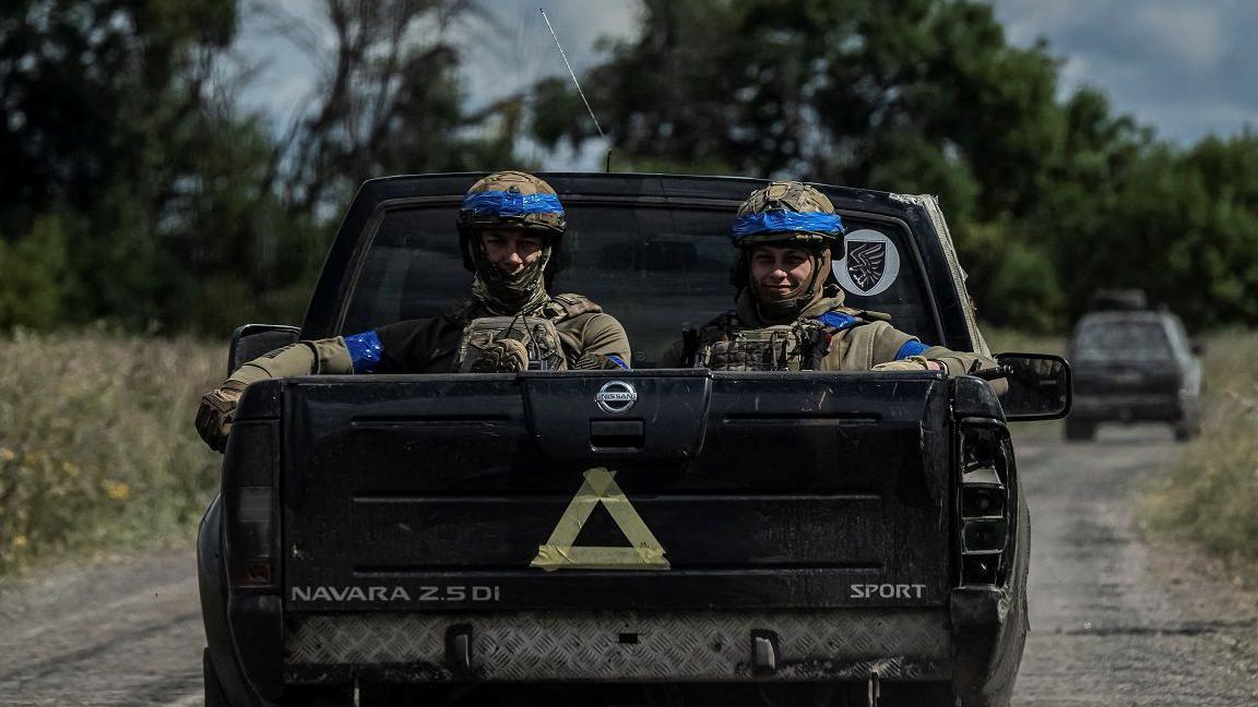 Soldados en una camioneta con un triángulo.