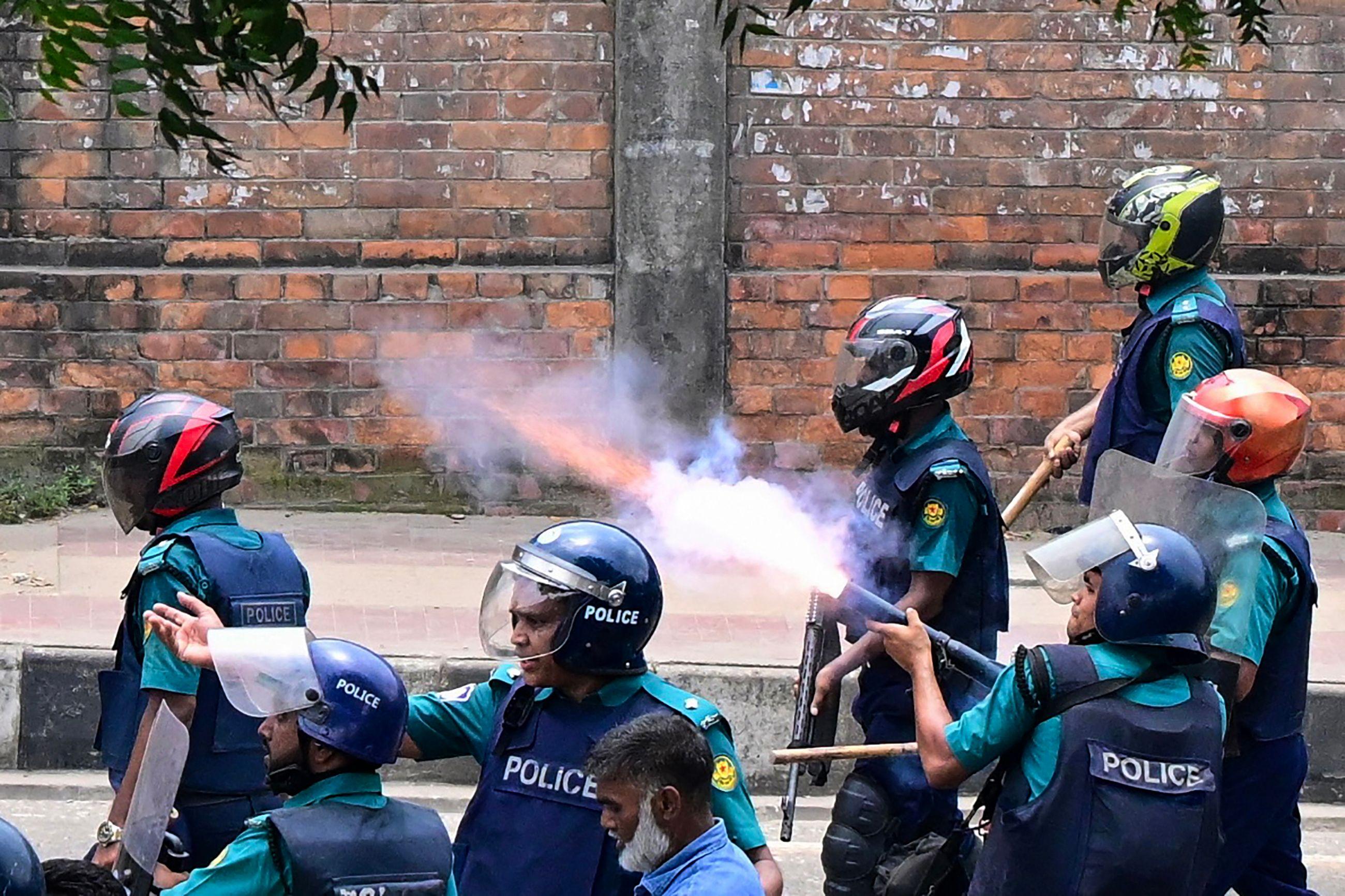 Polisi menembakkan gas air mata ke arah kerumunan demonstran.