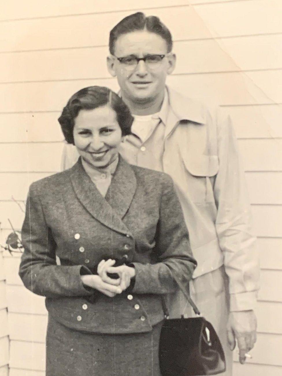 Los padres de Miguel Tinker Salas sonriendo, su madre con un elegante traje y su padre con un uniforme