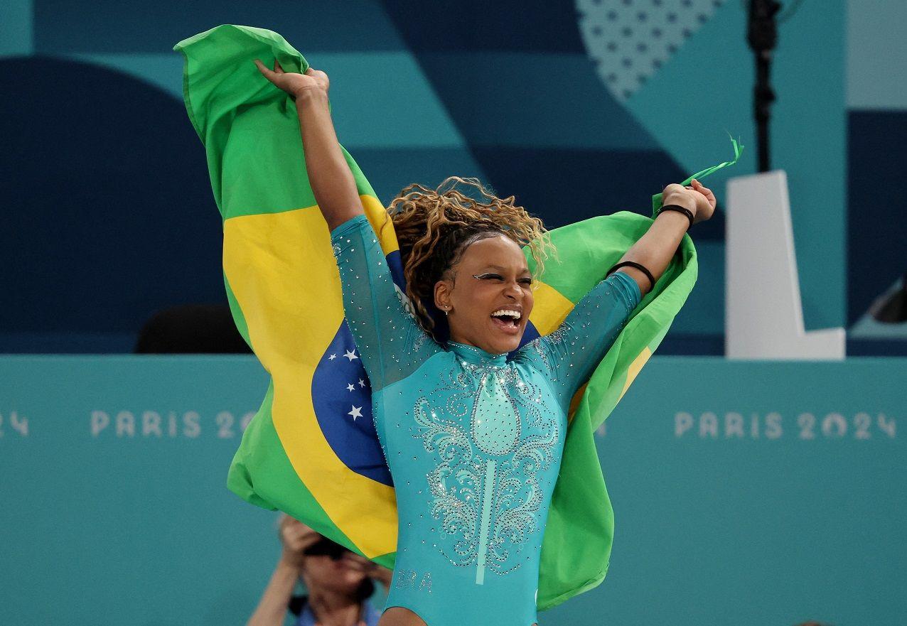 Rebeca vibra com a bandeira do Brasil nas mãos após conquistar ouro no solo nos Jogos de Paris 2024