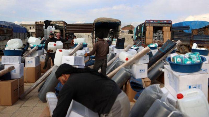 Voluntários distribuem ajuda humanitária em um acampamento improvisado em uma escola na cidade de Atareb
