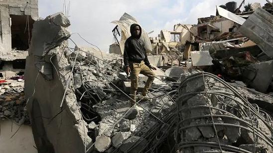 فلسطينيون يتفقدون الأنقاض بعد الهجمات الإسرائيلية في دير البلح