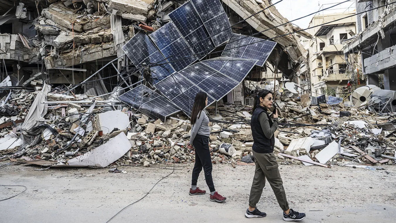 امرأتان تمُرّان بجوار أنقاض