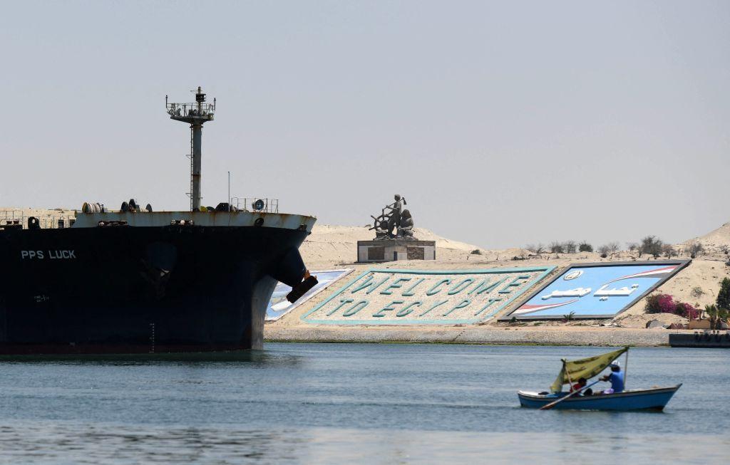Un barco cruzando el Canal de Suez cerca del letrero que dice Bienvenido a Egipto