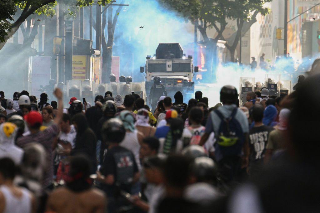 Manifesntantes frente a vehículos blindados