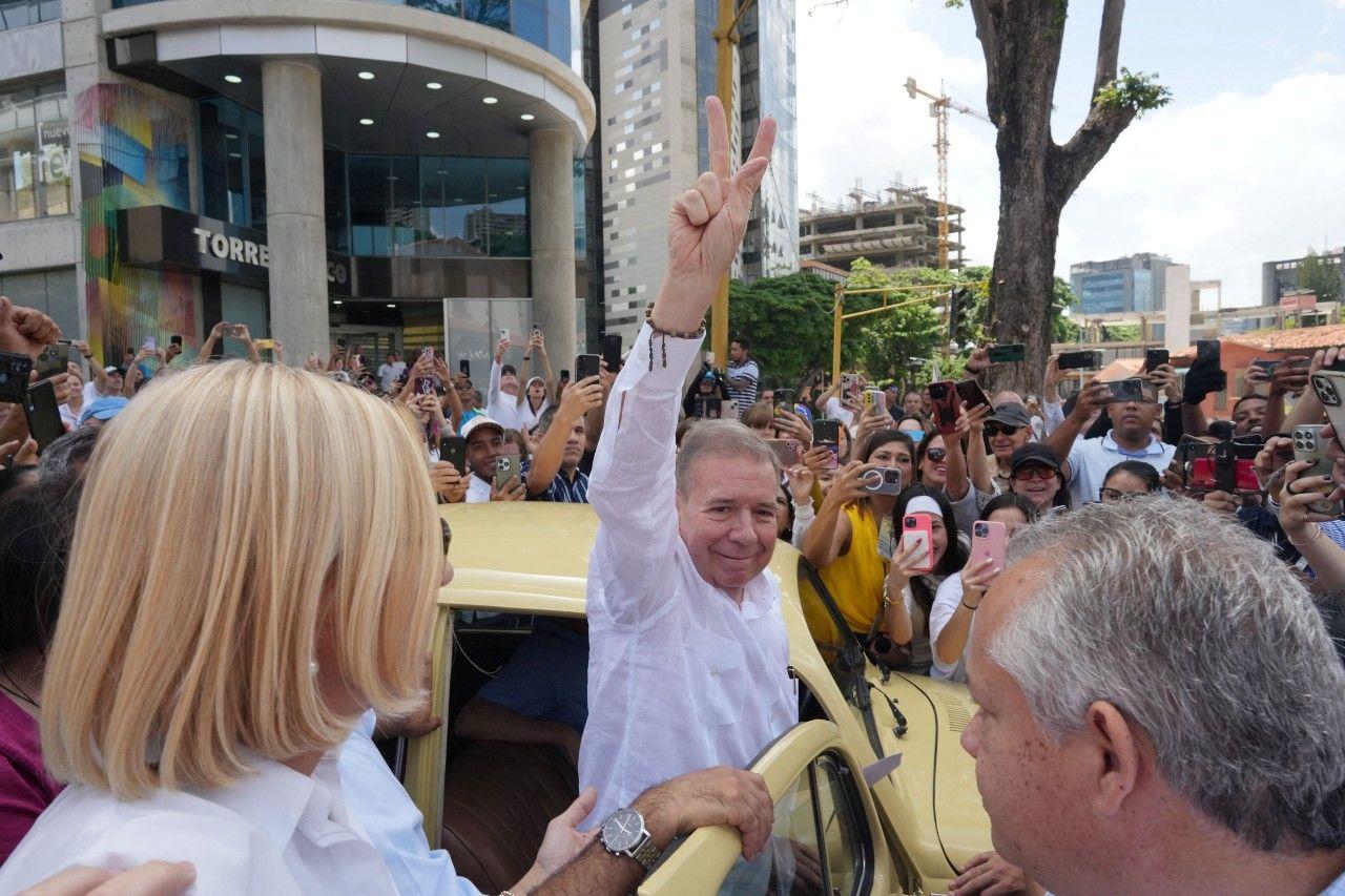 Edmundo González Urrutia sale de su coche, un escarabajo amarillo, para ir a votar, entre una multitud.