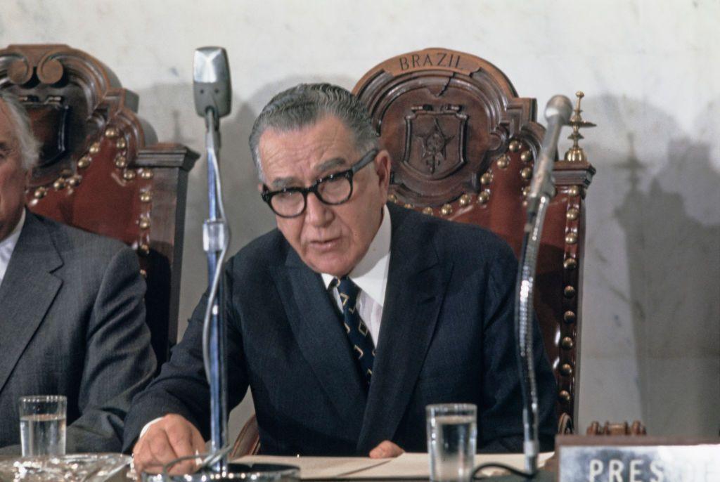 El presidente de Brasil en 1971, Emilio Garrastazu Médici, sentado en una silla con un micrófono en frente mientras se dirige a la Organización de los Estados Americanos en agosto de ese año. 