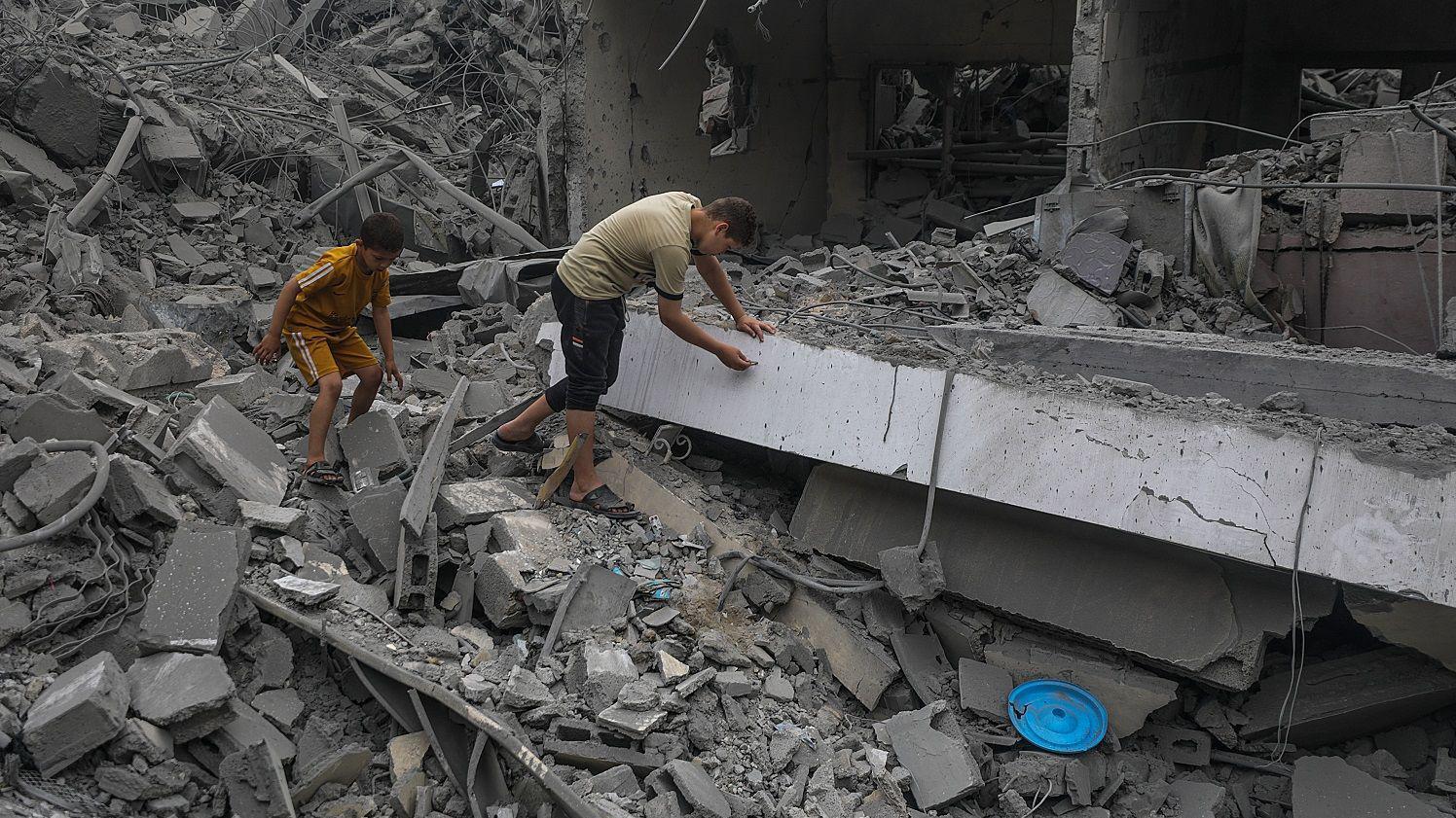 أطفال بين مبان مدمرة في غزة