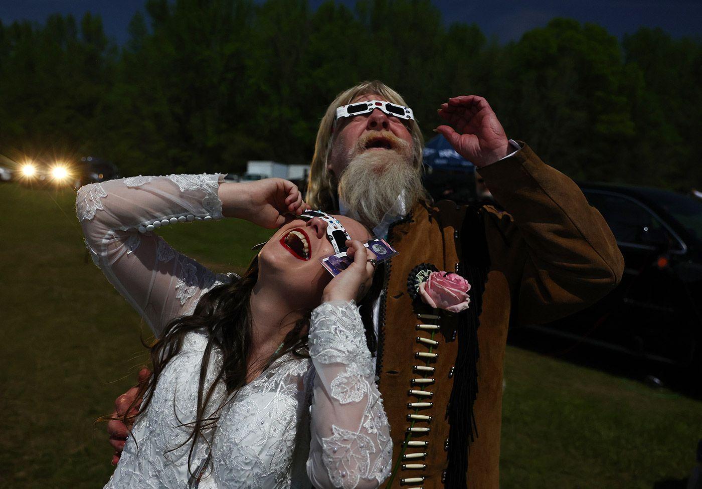 Casal observando o eclipse com óculos de proteção