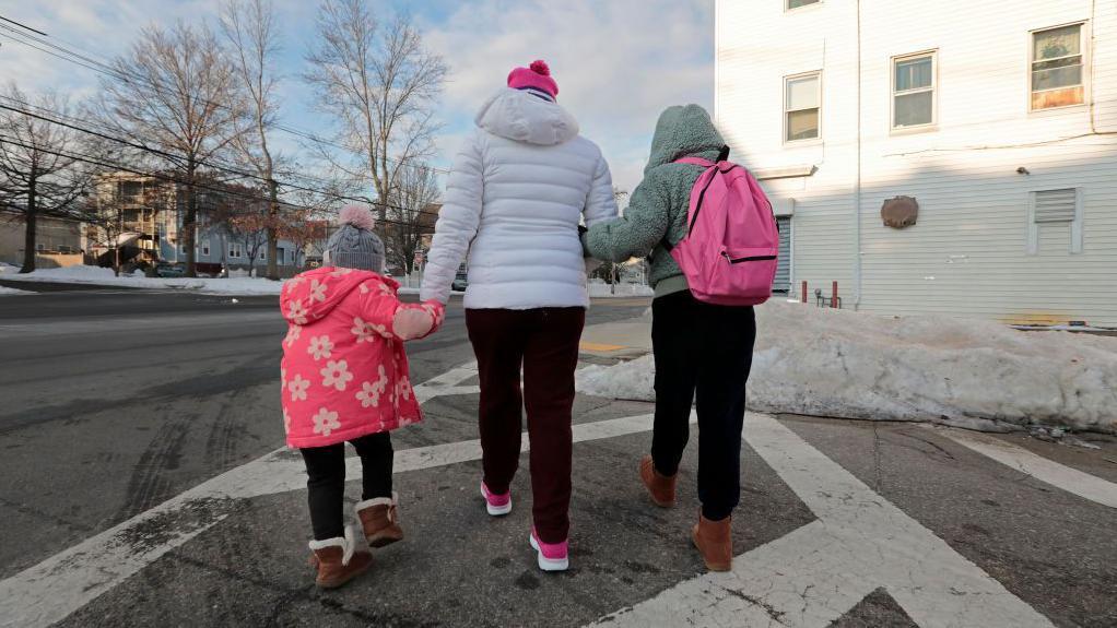 Una madre guatemalteca indocumentada camina con sus hijas de 3 y 9 años, para llevar a la niña mayor a la escuela. (Foto de Pat Greenhouse/The Boston Globe vía Getty Images)