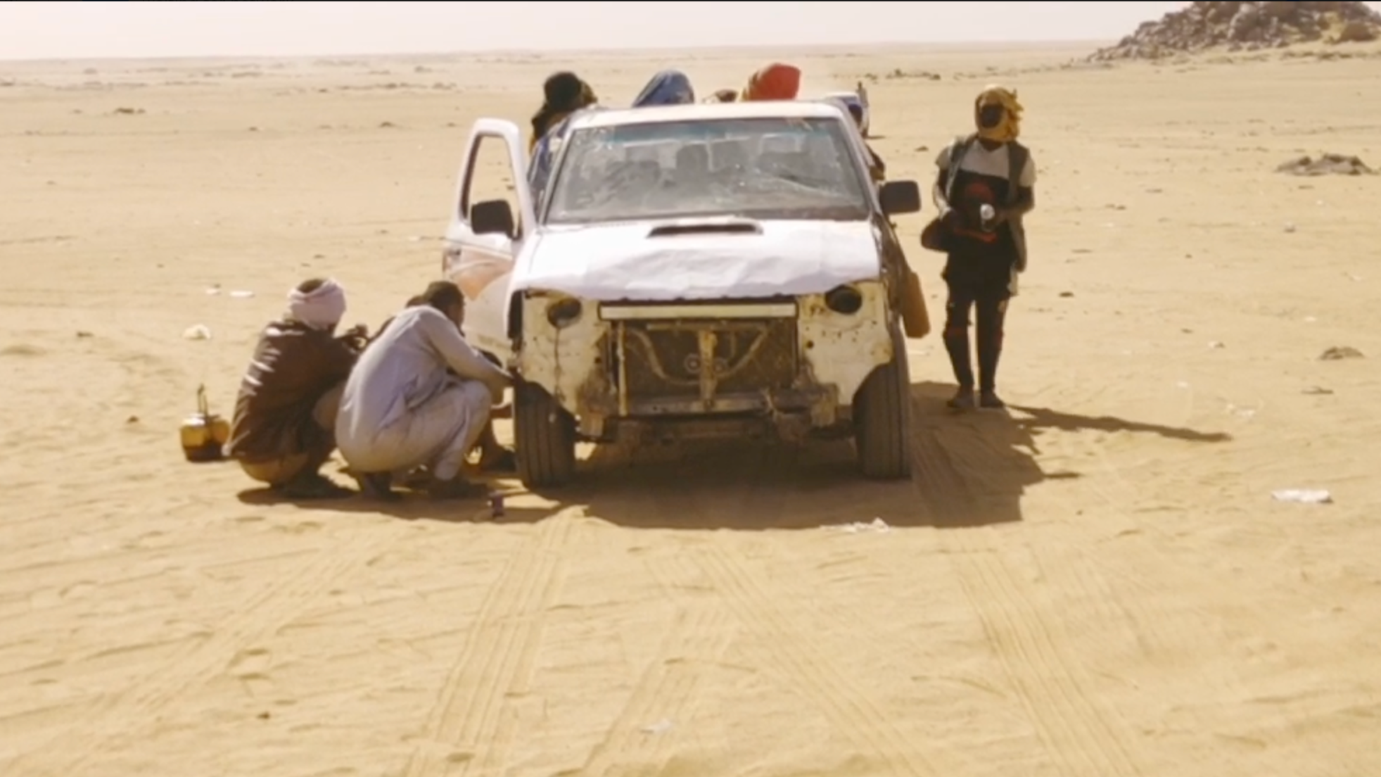 personas viajan en una camioneta por el desierto entre sudán y egipto