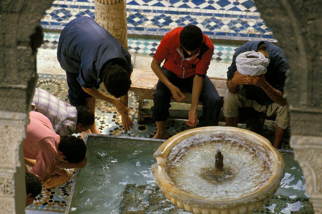 صورة لأفراد يتوضأون الماء من حوض في جامع القرويين