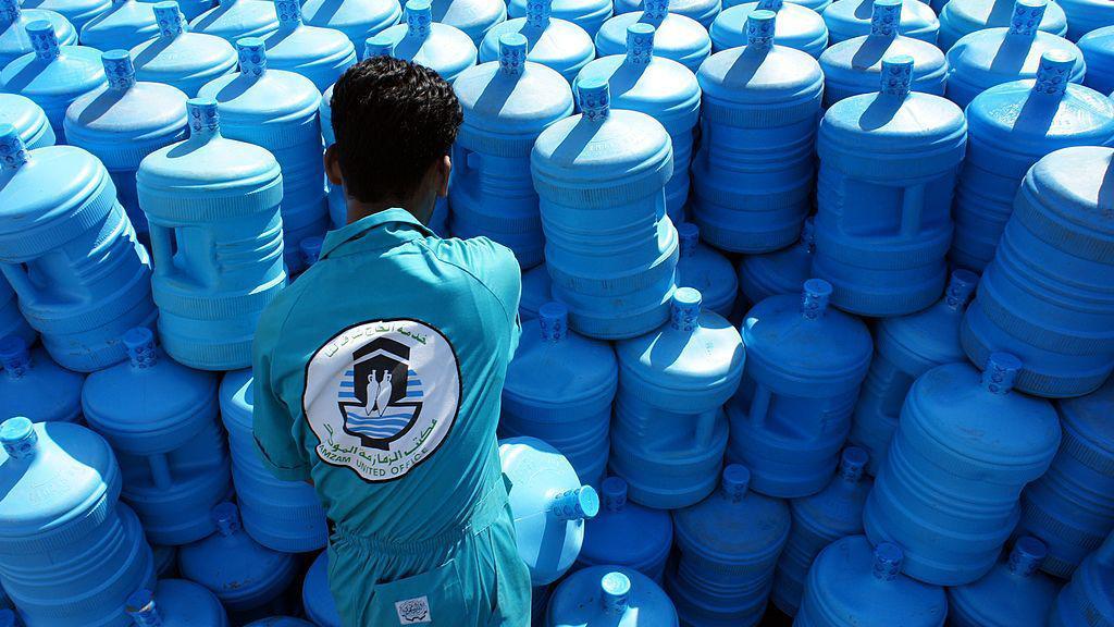 A Saudi worker loads carboys of 