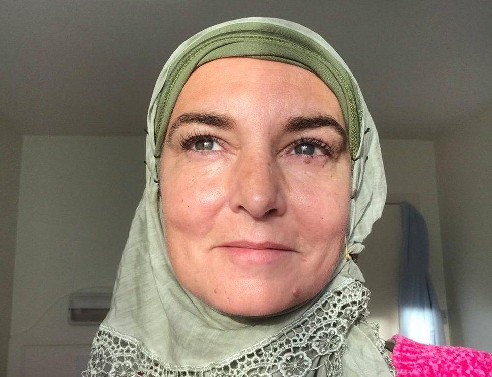 Sinead O'Connor com a cabeça coberta por lenço