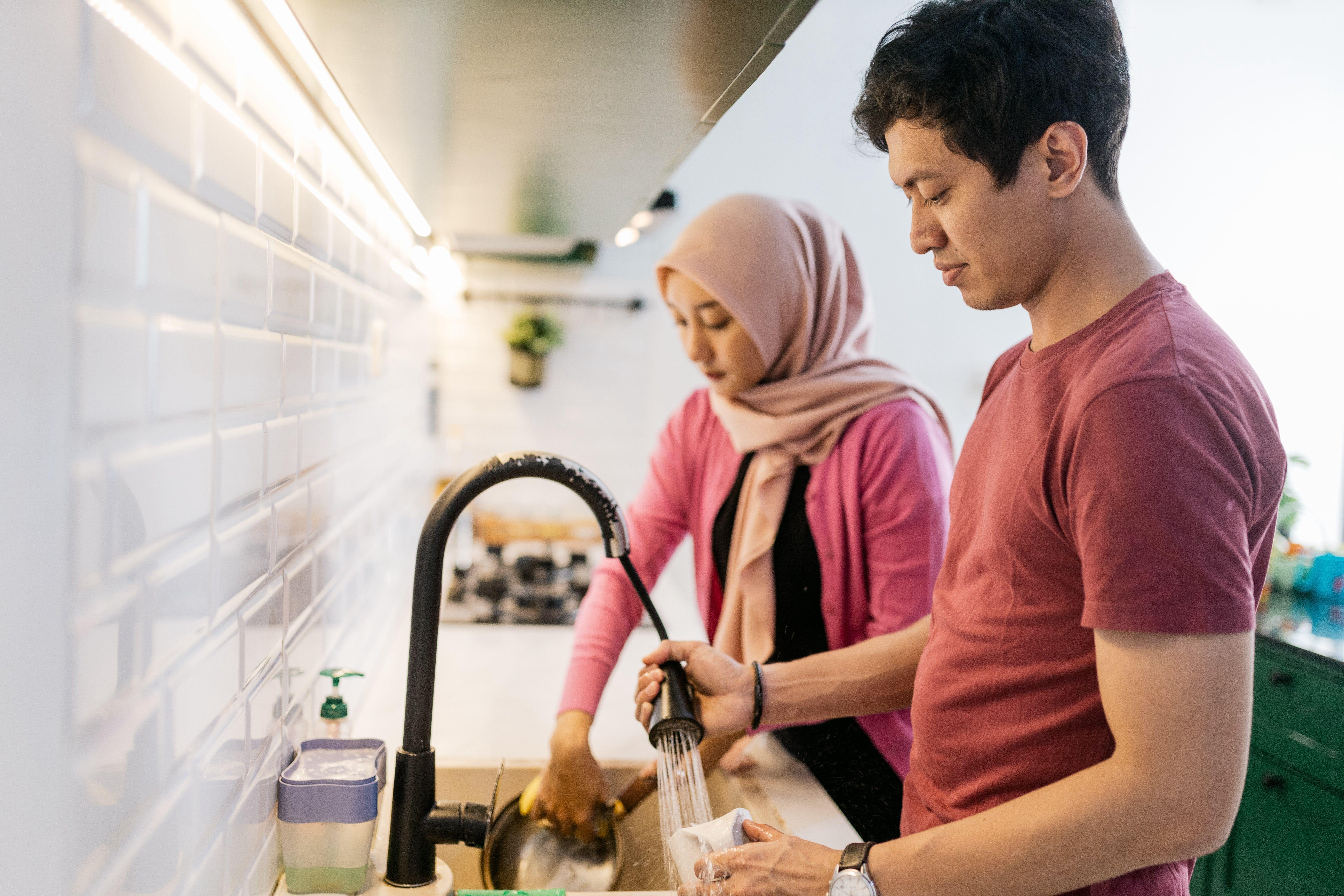 امرأة ورجل يغسلان الأطباق معاً
