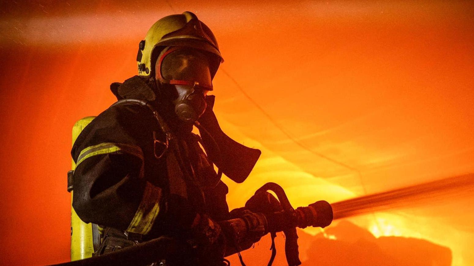  رجل إطفاء يعمل في موقع من منشآت التخزين التي تعرضت لضربات صاروخية وطائرات مسيرة روسية، على أوديسا، أوكرانيا، 19 يوليو / تموز 2023.