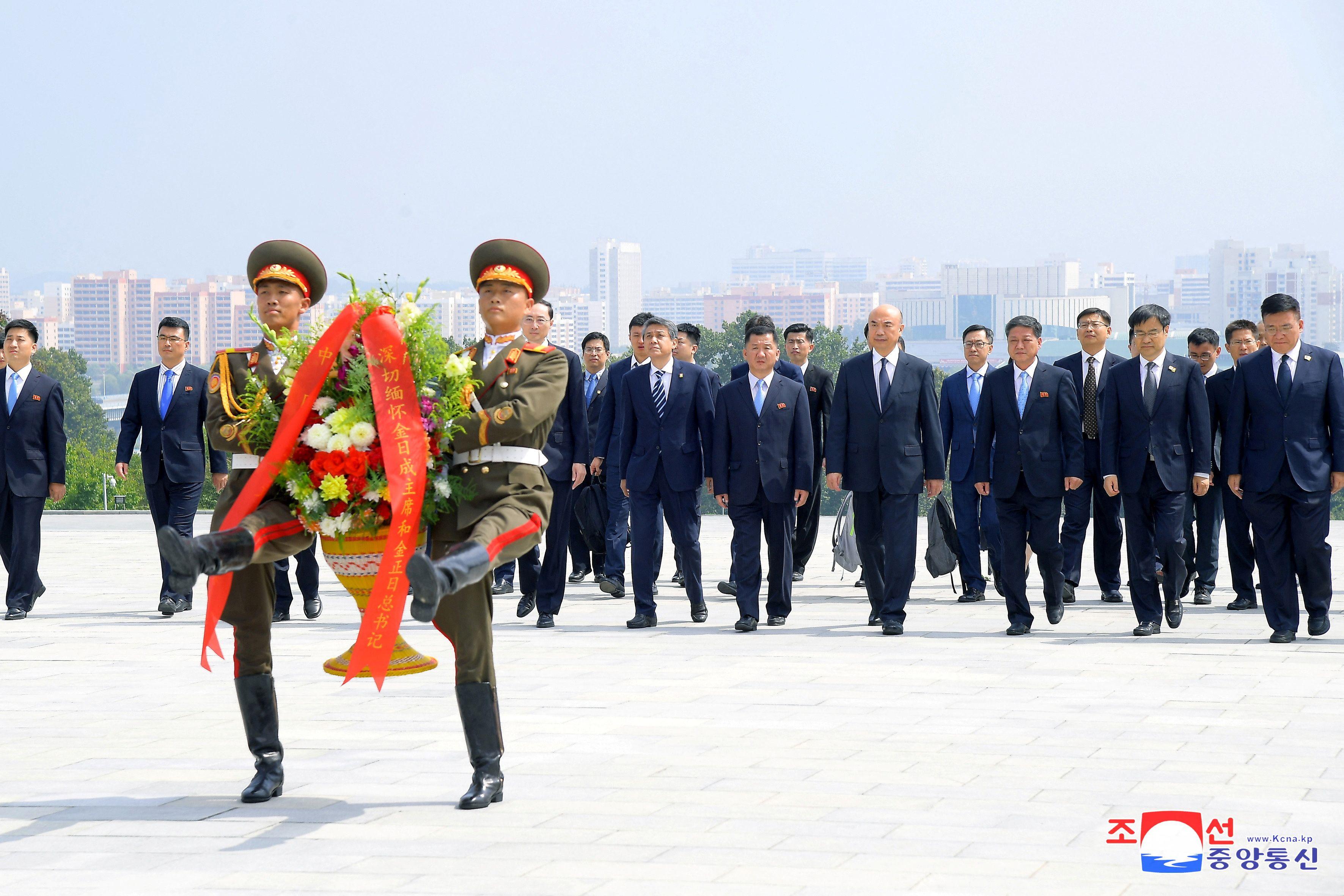 Una delegación de China coloca una ofrenda florar