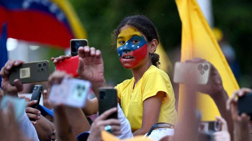 Niña con la bandera de Venezuela pintada en la cara. 