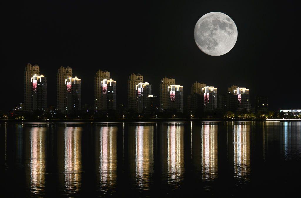 A Lua Cheia do Caçador no céu noturno sobre edifícios em 16 de outubro de 2024 em Weihai, província de Shandong, China.