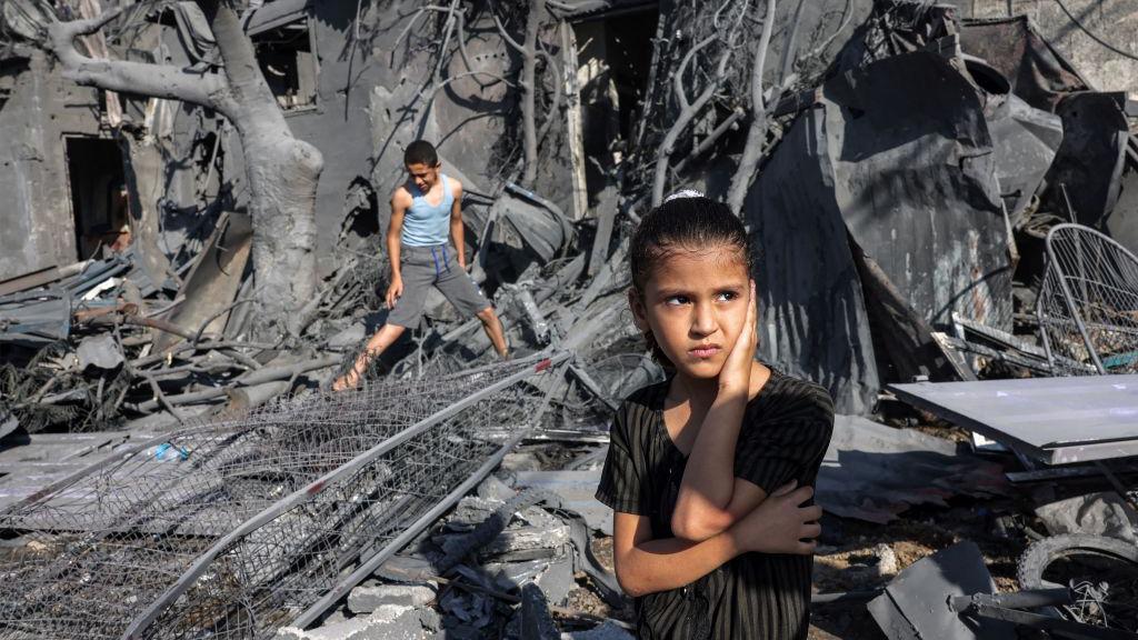 Two children in a scene of destruction in Gaza