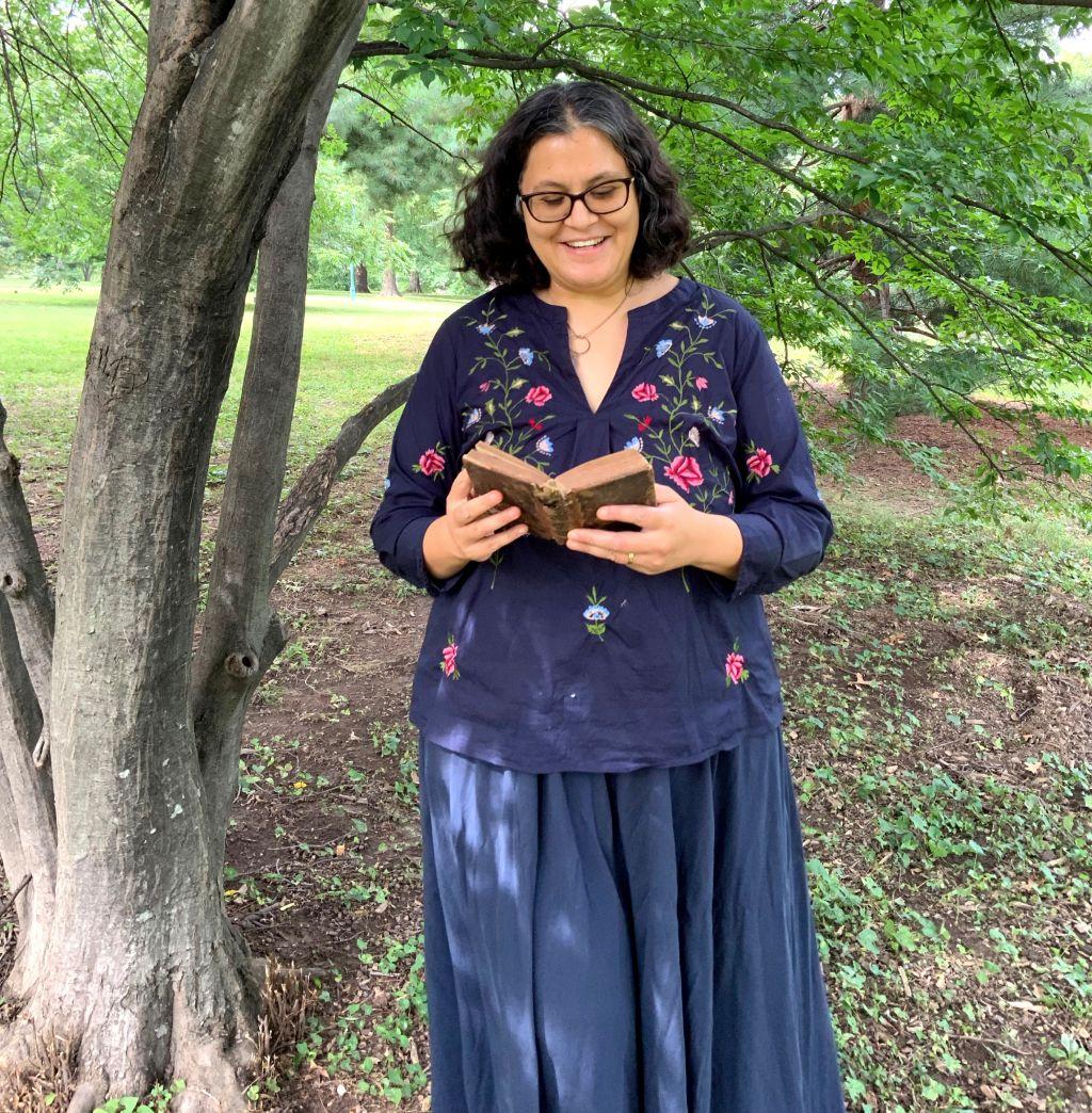 Helen de Cruz leyendo bajo un árbol