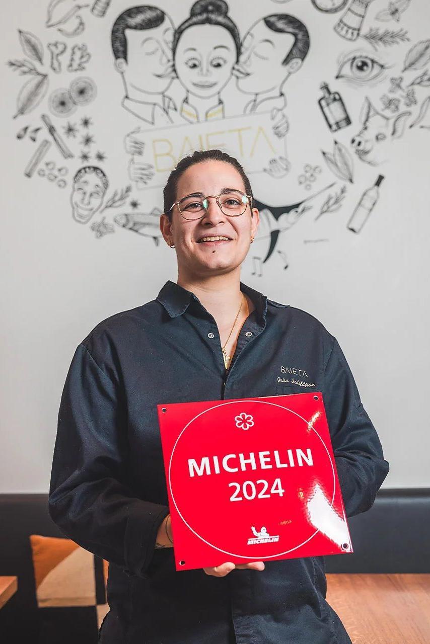 Boss segura uma placa vermelha dizendo Michelin 2024. 