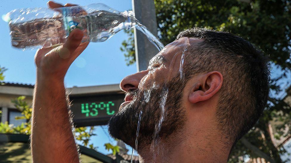 Hombre lanzando agua sobre su cabeza durante una ola de calor