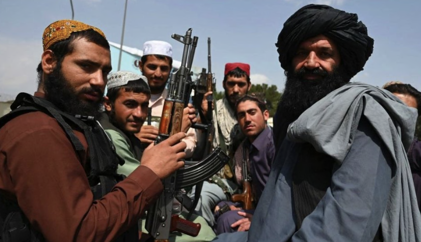 Talban militants with guns on back of a pickup truck