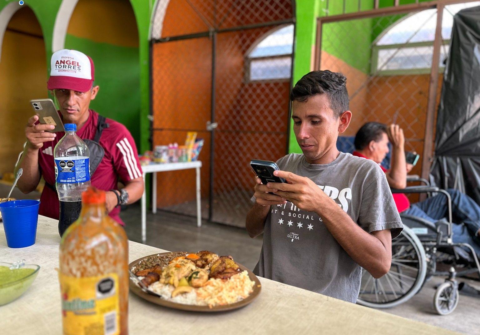 Carlos José Soto, migrante de Carabobo, Venezuela, saca una foto a su ansiado almuerzo venezolano. 