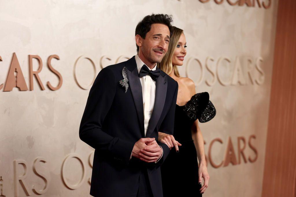 Adrien Brody, estrella de The Brutalist ("El brutalista") y aspirante a mejor actor, en la alfombra roja de los Oscar 2025 con su mujer, la diseñadora Georgina Chapman, en el teatro Dolby de Hollywood, Los Ángeles, Estados Unidos, el 2 de marzo de 2025.