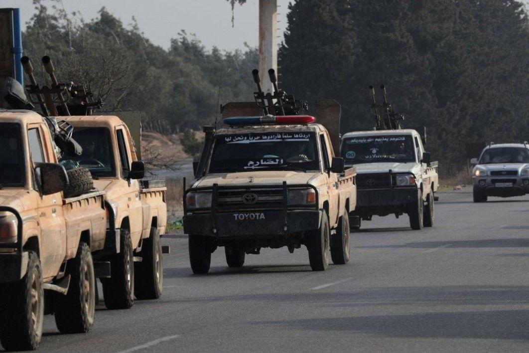 مقاتلون تابعون للإدارة السورية الجديدة في دورية من مركبات ( بيك أب) في مدينة حمص- الصورة التقطت نهاراً.