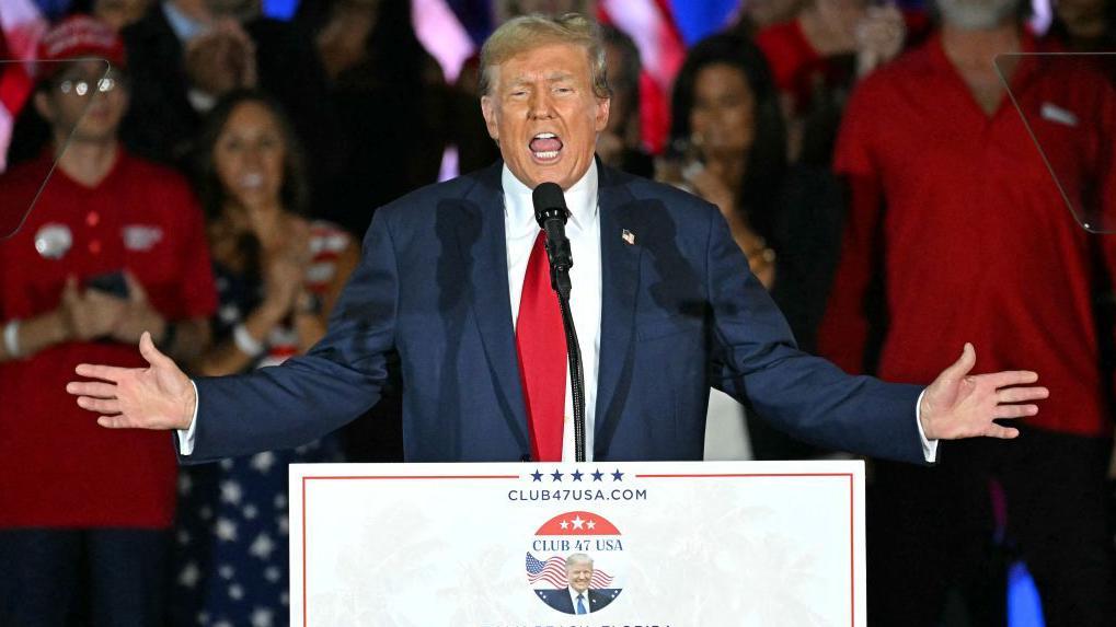 Donald Trump mantiene los brazos abiertos mientras pronuncia un discurso durante un evento de campaña en Florida en junio de 2024.