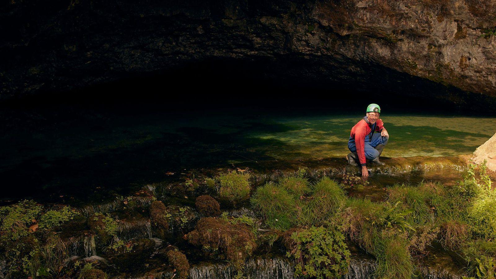 Un hombre afuera de una cueva. 