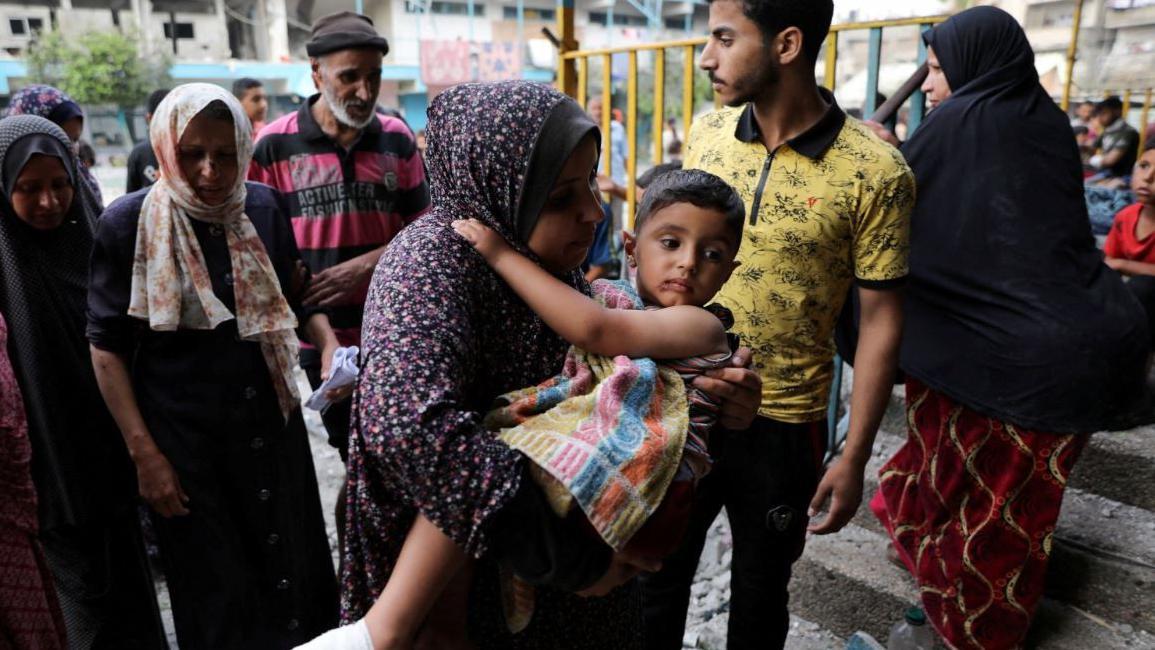 Una mujer carga a un niño