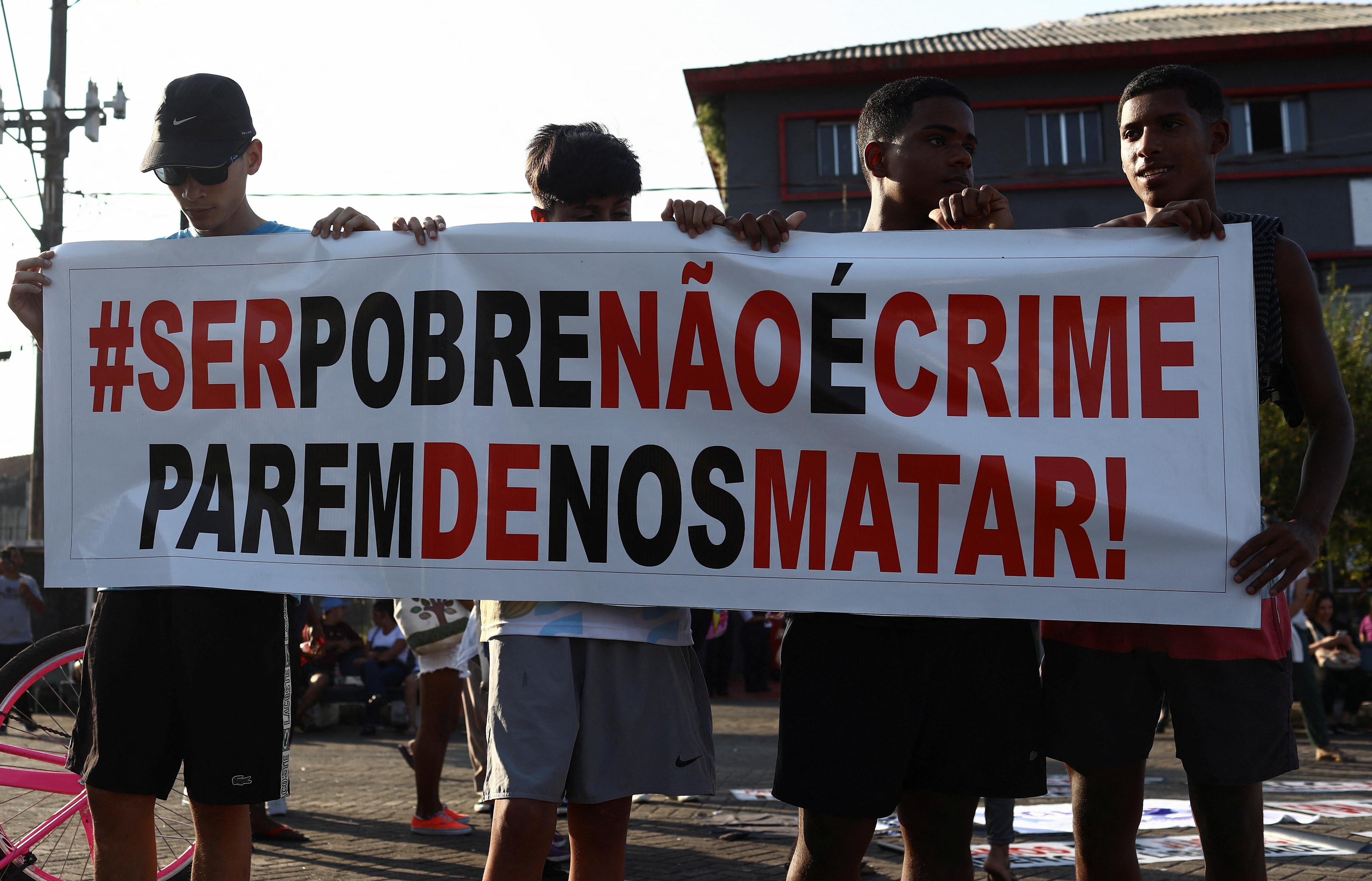 Jovens seguram faixa durante protesto contra operação na Baixada