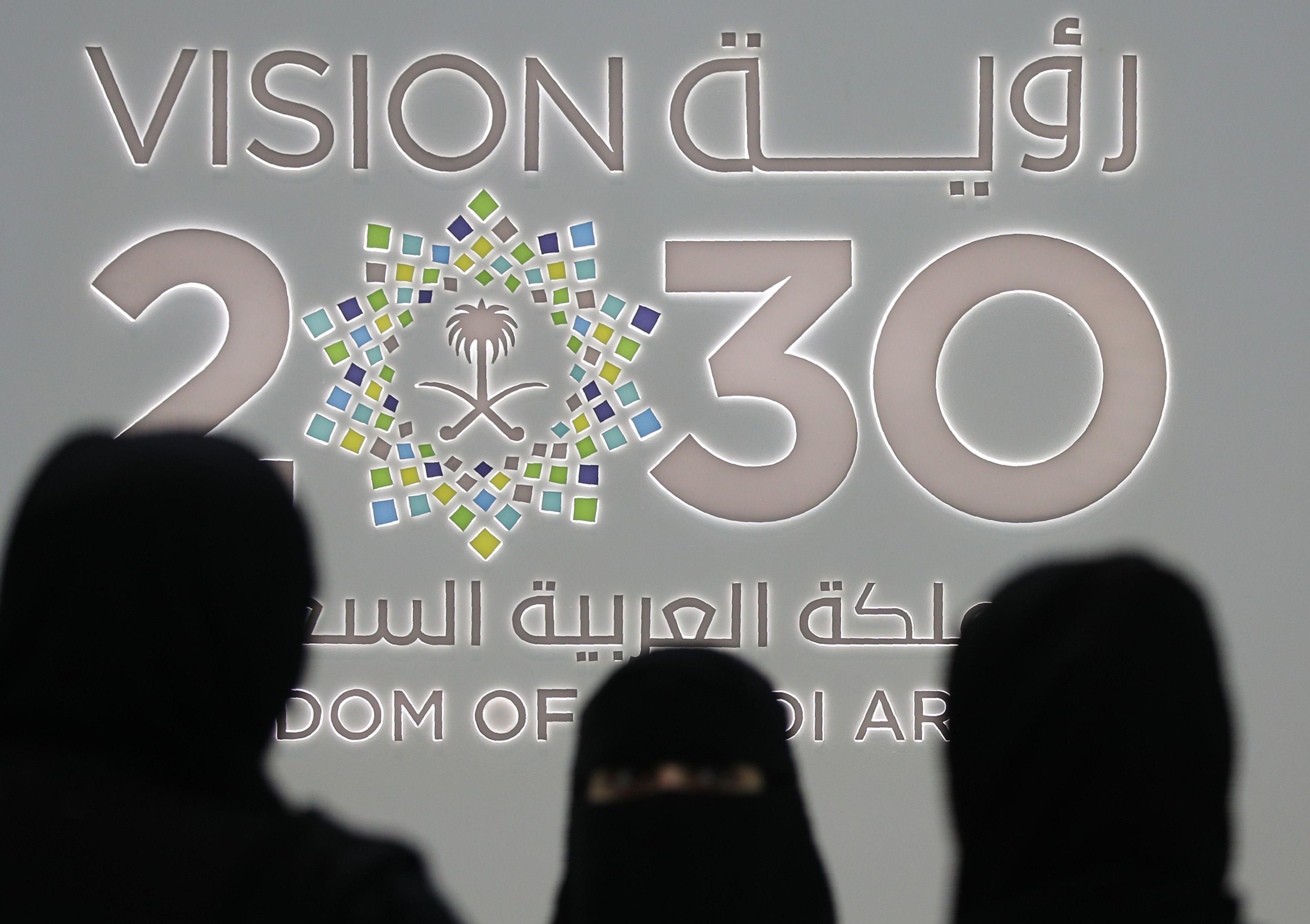نساء سعوديات يقفن بجانب جناح المملكة العربية السعودية (رؤية 2030) في معرض جيتكس 2018 بمركز دبي التجاري العالمي في دبي، بتاريخ 16 أكتوبر/ تشرين الاول 2018.