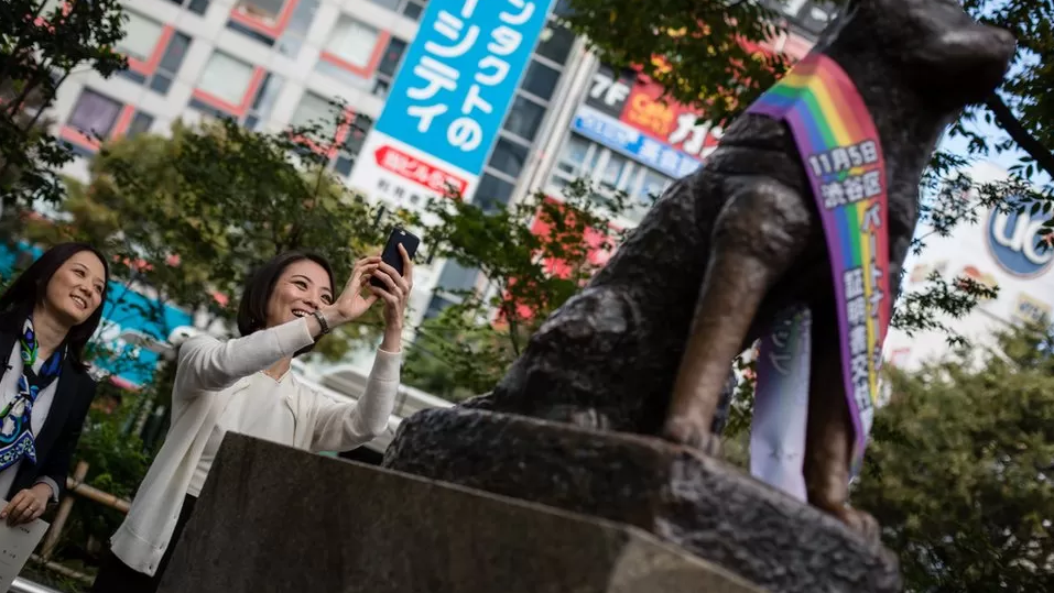 نساء يلتقطن صورة لتمثال هاتشيكو