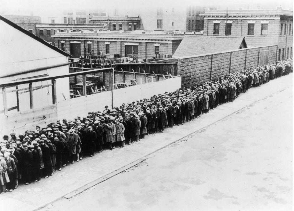 Trabajadores y desempleados forman una larga fila para conseguir un plato de comida gratuito en Nueva York en la década de 1930.