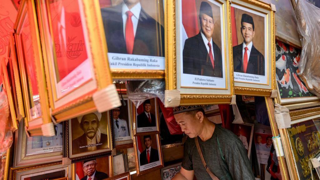 Seorang pedagang menjual foto Presiden terpilih Indonesia Prabowo Subianto (tengah) dan Wakil Presiden terpilih Gibran Rakabuming Raka (kanan) di Jakarta.