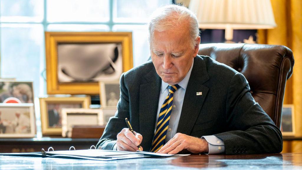 El presidente Biden firma un documento en el Despacho Oval