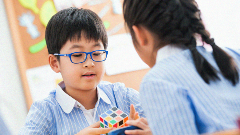 Niños jugando con cubo de Rubik. 