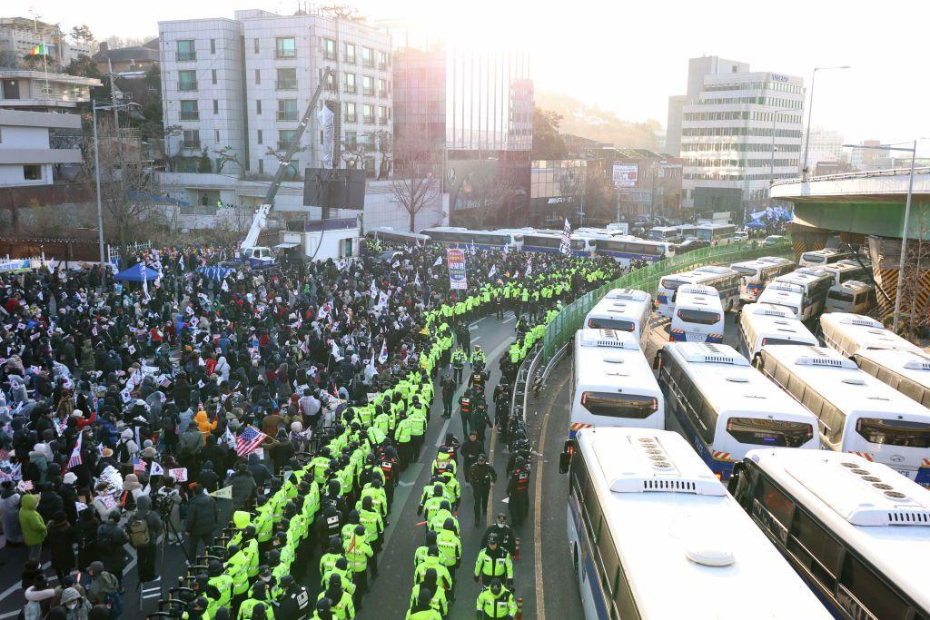 Policías frente a los manifestantes que protestan en contra del arresto del presidente Yoon.