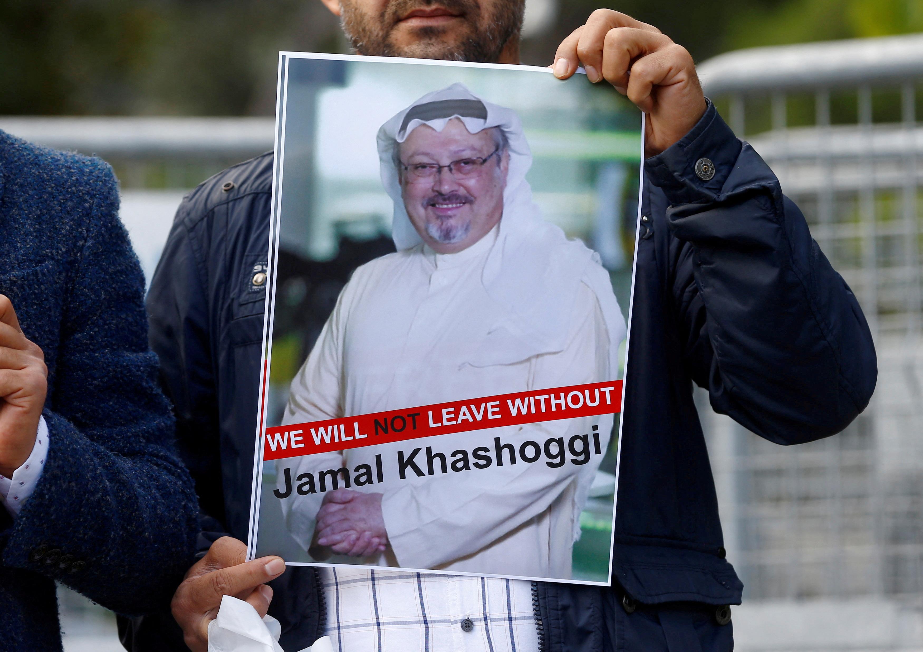 Homem segurando cartaz com rosto do jornalista Jamal Khashoggi