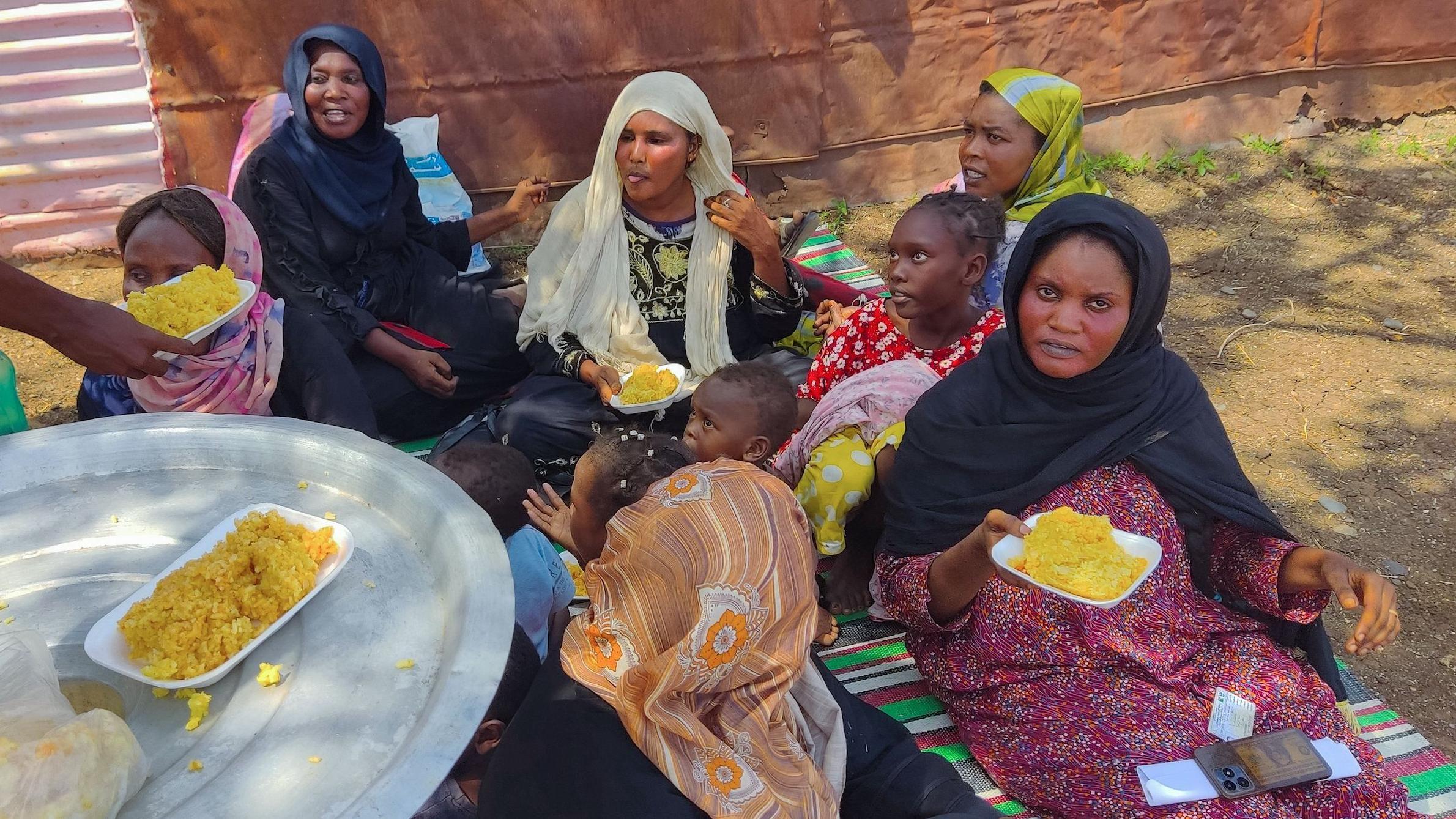 يتلقى الأشخاص الفارون من الصراع في جنوب شرق السودان وجبات طعام من إحدى الجمعيات الخيرية أثناء استراحتهم في مخيم مؤقت.